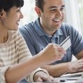 Couple using credit card and laptop to shop online Couple using credit card and laptop to shop online